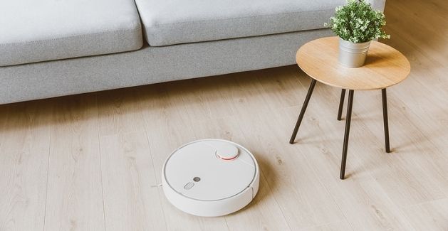 a robot floor cleaner on a natural wide-plank wood floor